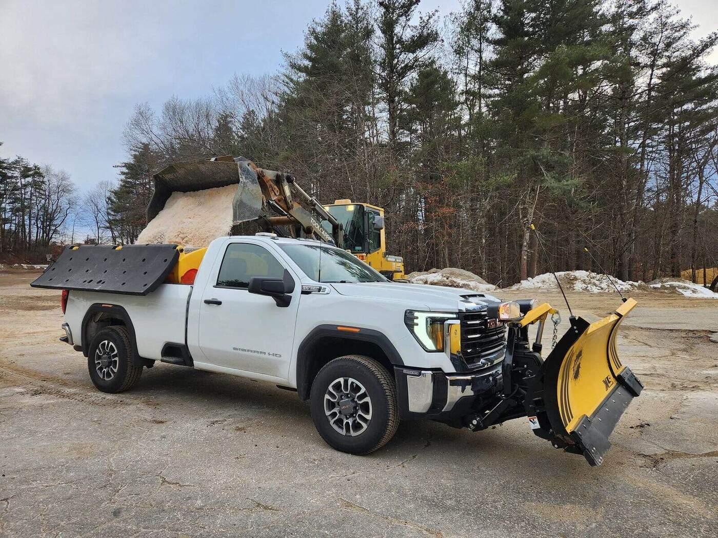 Plow truck loaded for winter work outside a commercial building