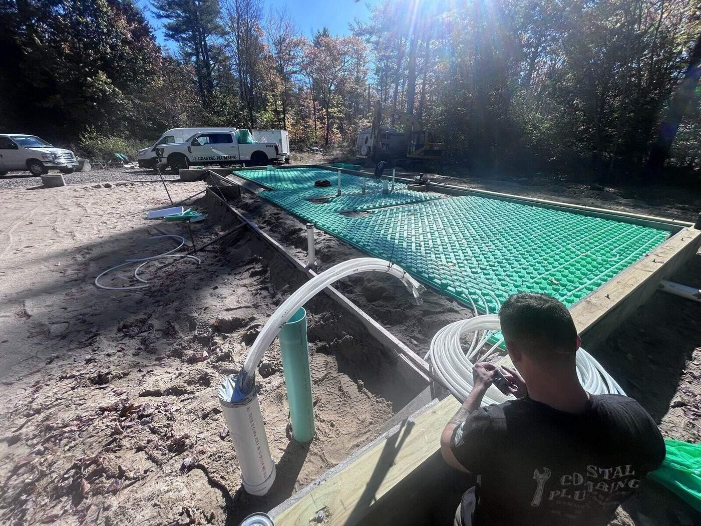 HVAC technician installing radiant floor heating on a new build